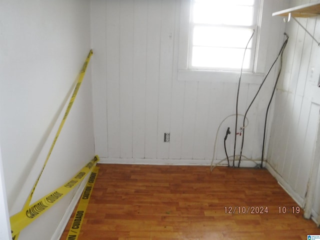 unfurnished room with wood walls and hardwood / wood-style flooring