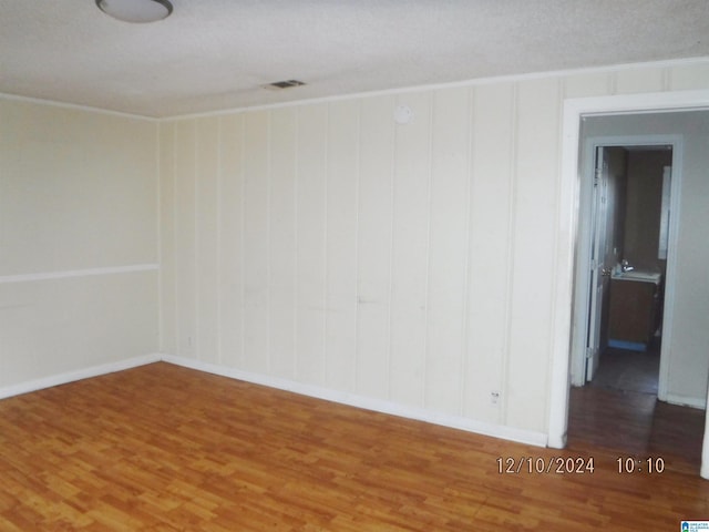 empty room with wood-type flooring and a textured ceiling