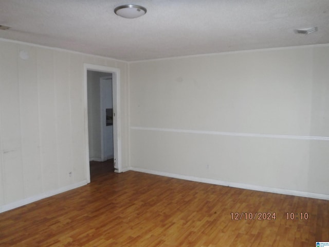 spare room featuring hardwood / wood-style floors and a textured ceiling