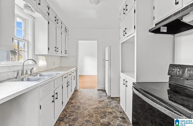 kitchen featuring sink, black electric range, white cabinets, and ventilation hood