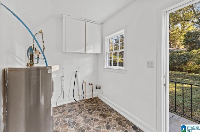 laundry room with water heater and a healthy amount of sunlight