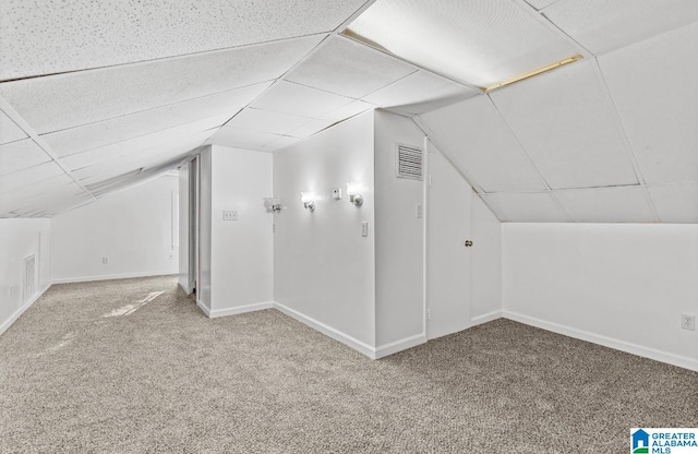 bonus room with carpet floors and vaulted ceiling