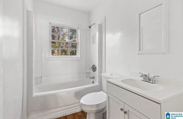 full bathroom featuring toilet, hardwood / wood-style floors, vanity, and bathing tub / shower combination