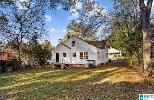 rear view of house featuring a yard