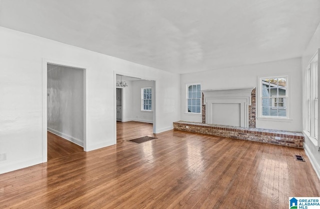 unfurnished living room with a chandelier and wood-type flooring