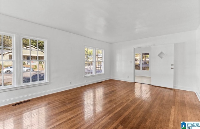 spare room featuring hardwood / wood-style flooring and plenty of natural light