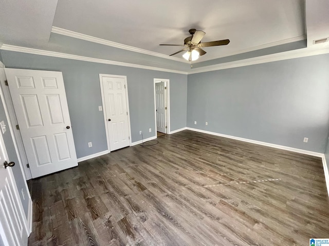 unfurnished bedroom with a tray ceiling, ceiling fan, and dark hardwood / wood-style floors