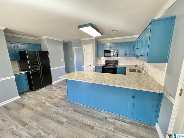 kitchen featuring blue cabinetry, kitchen peninsula, light hardwood / wood-style flooring, and black appliances