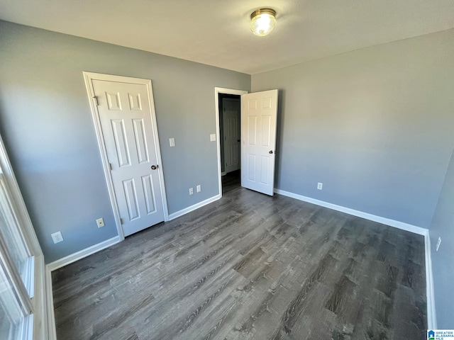 unfurnished bedroom with a closet and dark hardwood / wood-style floors