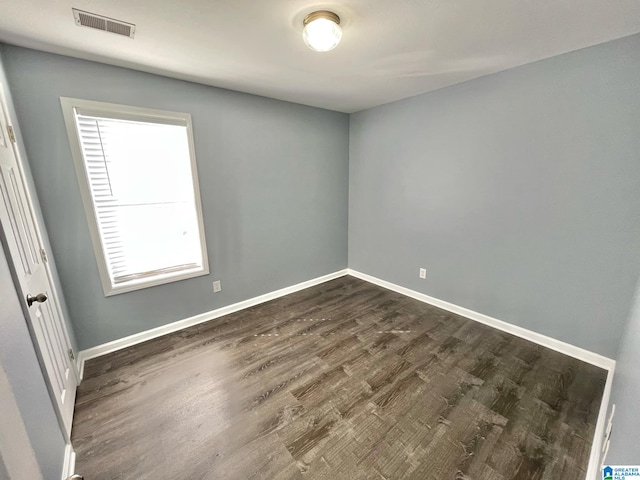 empty room with dark hardwood / wood-style flooring