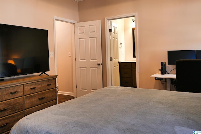 bedroom with dark wood-type flooring and ensuite bathroom