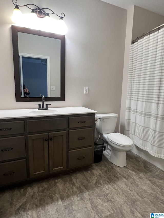 bathroom with toilet, vanity, and curtained shower