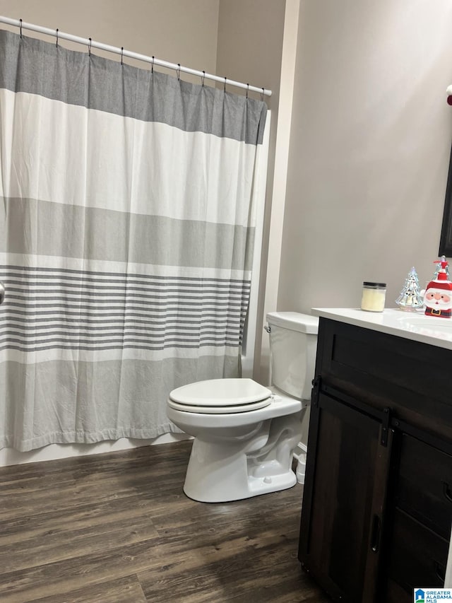 bathroom featuring curtained shower, wood-type flooring, toilet, and vanity