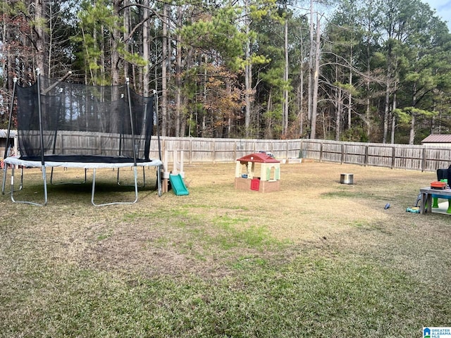 view of community featuring a playground, a lawn, and a trampoline