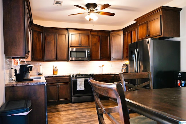 kitchen with ceiling fan, appliances with stainless steel finishes, backsplash, dark brown cabinets, and wood-type flooring