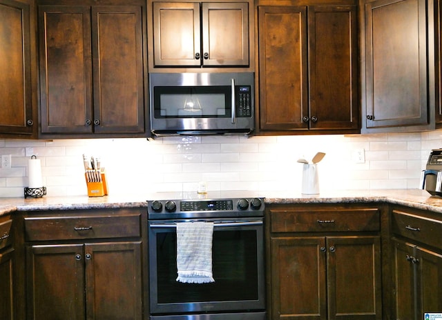 kitchen featuring backsplash, appliances with stainless steel finishes, and dark brown cabinetry