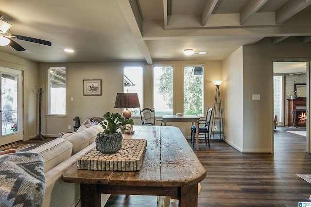 living room featuring beam ceiling, ceiling fan, and dark wood-type flooring