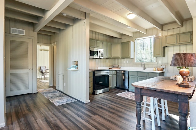 kitchen featuring beamed ceiling, sink, dark hardwood / wood-style flooring, and stainless steel appliances