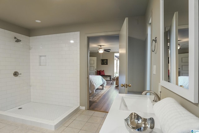 bathroom with a tile shower, ceiling fan, vanity, and hardwood / wood-style flooring