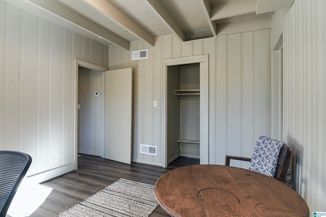 interior space featuring beam ceiling, dark hardwood / wood-style floors, and wood walls