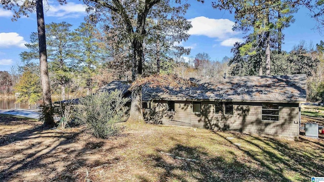 back of house with a yard and a water view