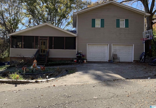 view of front of property with a garage and a sunroom