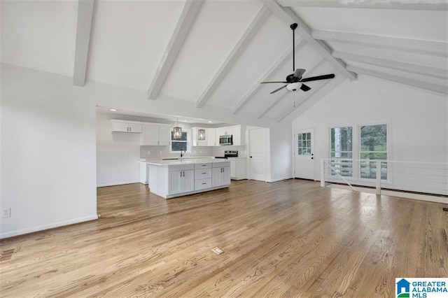 unfurnished living room with beam ceiling, ceiling fan, sink, light hardwood / wood-style flooring, and high vaulted ceiling