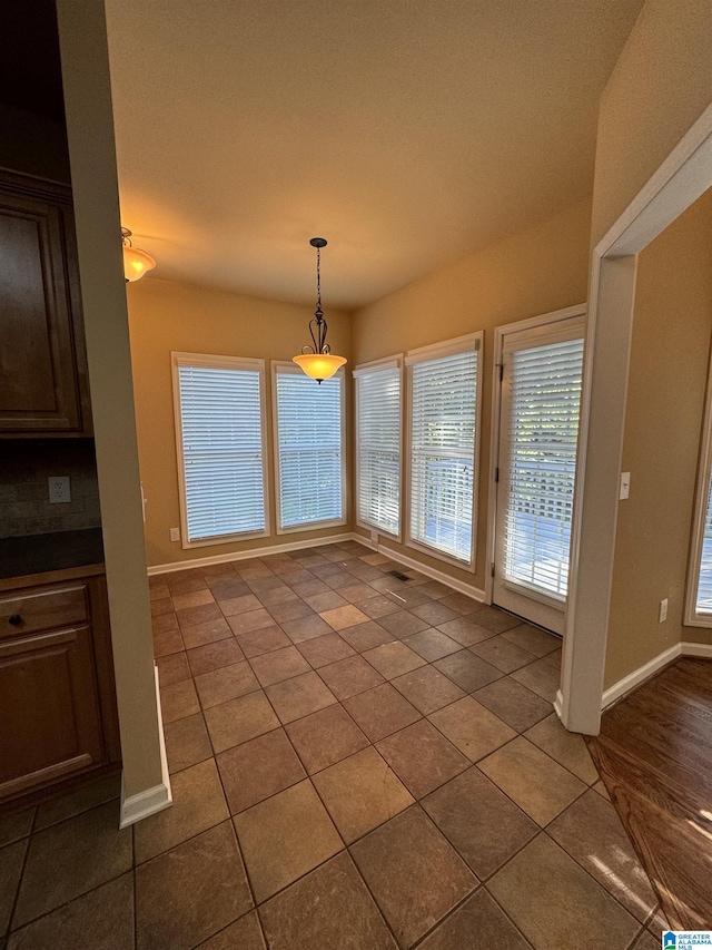 unfurnished dining area featuring tile patterned floors