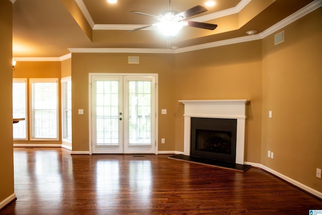 unfurnished living room featuring ceiling fan, french doors, a raised ceiling, crown molding, and hardwood / wood-style floors