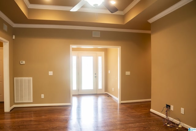 spare room with dark hardwood / wood-style flooring, a raised ceiling, ceiling fan, and crown molding