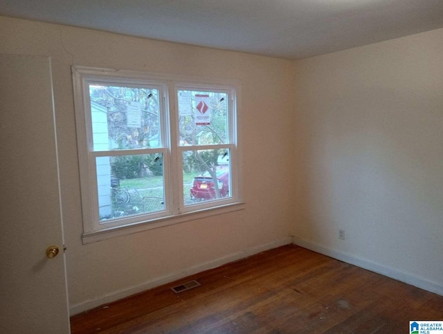 unfurnished room with dark hardwood / wood-style flooring