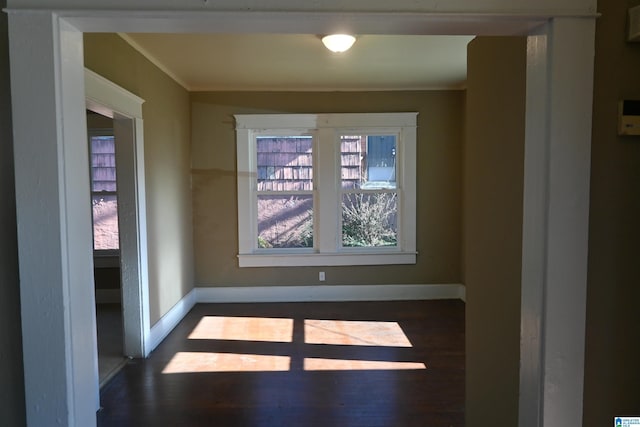 unfurnished room featuring dark hardwood / wood-style flooring and crown molding