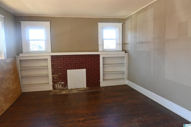 unfurnished living room featuring dark hardwood / wood-style flooring, plenty of natural light, radiator, and crown molding