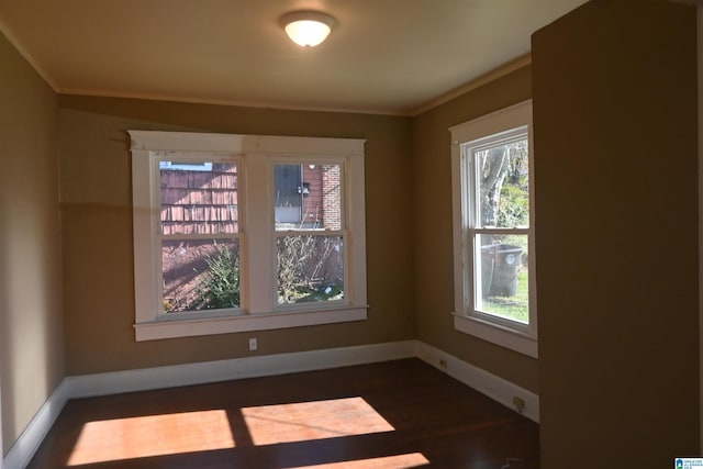 unfurnished room featuring plenty of natural light, dark hardwood / wood-style flooring, and crown molding