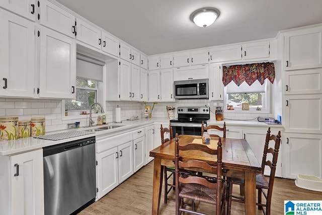 kitchen featuring light wood-type flooring, white cabinetry, sink, and appliances with stainless steel finishes