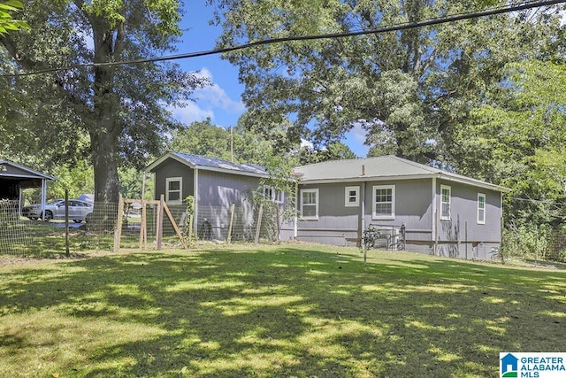 rear view of property featuring a lawn