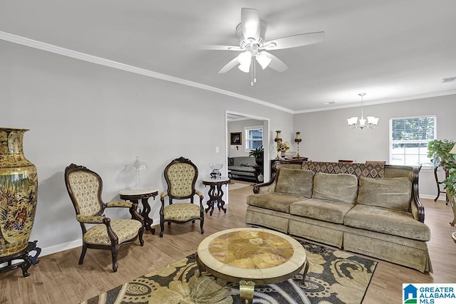 living room with ornamental molding, ceiling fan with notable chandelier, and light wood-type flooring