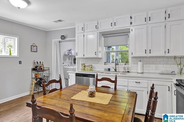 kitchen featuring appliances with stainless steel finishes, white cabinetry, a wealth of natural light, and sink