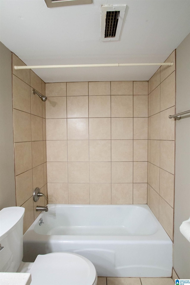 bathroom with toilet and tiled shower / bath