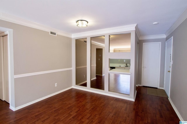 unfurnished bedroom featuring sink, crown molding, and dark wood-type flooring