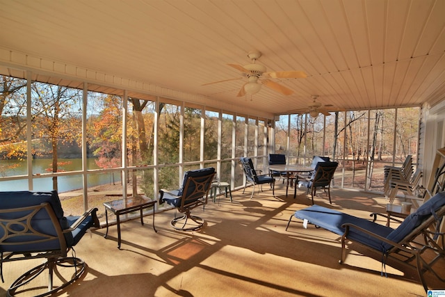 unfurnished sunroom with wood ceiling, ceiling fan, a water view, and a healthy amount of sunlight