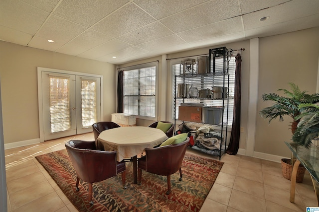 sitting room featuring a drop ceiling, light tile patterned floors, and french doors