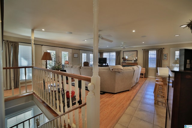 living room featuring french doors, light hardwood / wood-style flooring, ceiling fan, and ornamental molding