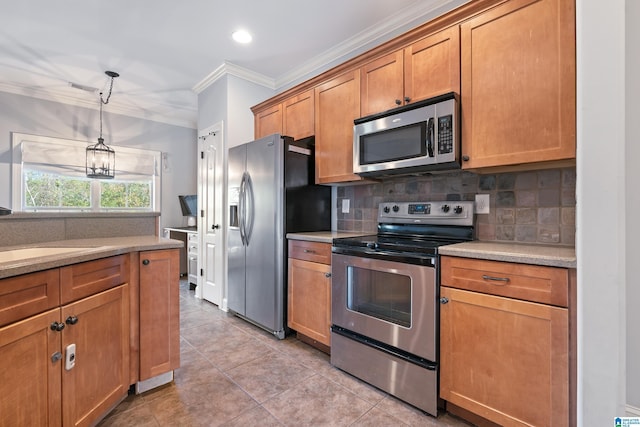 kitchen with sink, stainless steel appliances, decorative light fixtures, light tile patterned floors, and ornamental molding