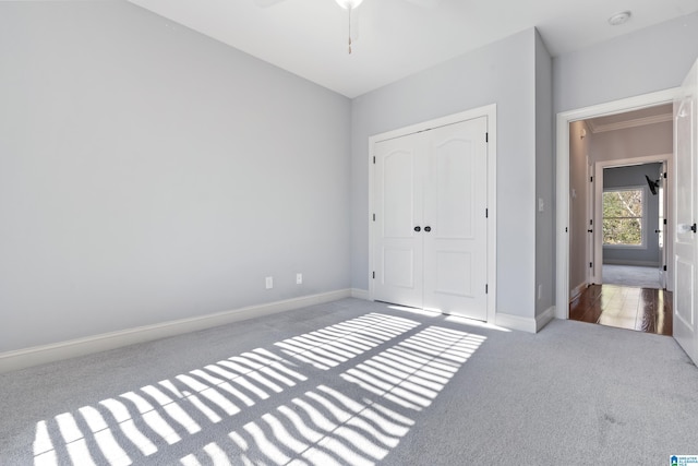 unfurnished bedroom featuring ceiling fan, a closet, and carpet