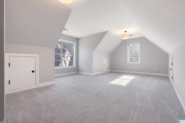 bonus room with lofted ceiling, light carpet, and a wealth of natural light