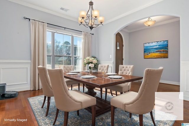 dining area with a notable chandelier, dark hardwood / wood-style floors, and crown molding