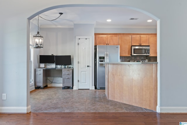 kitchen with stainless steel appliances, dark hardwood / wood-style flooring, crown molding, a chandelier, and decorative backsplash