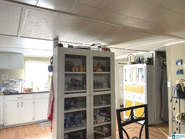 interior space featuring light wood-type flooring and white cabinetry