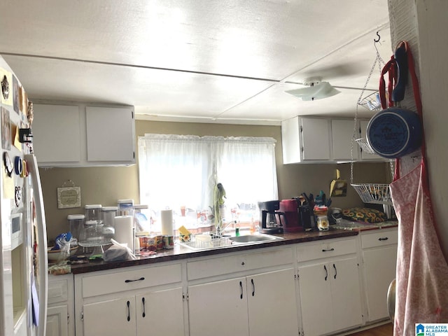 kitchen featuring sink and white cabinets